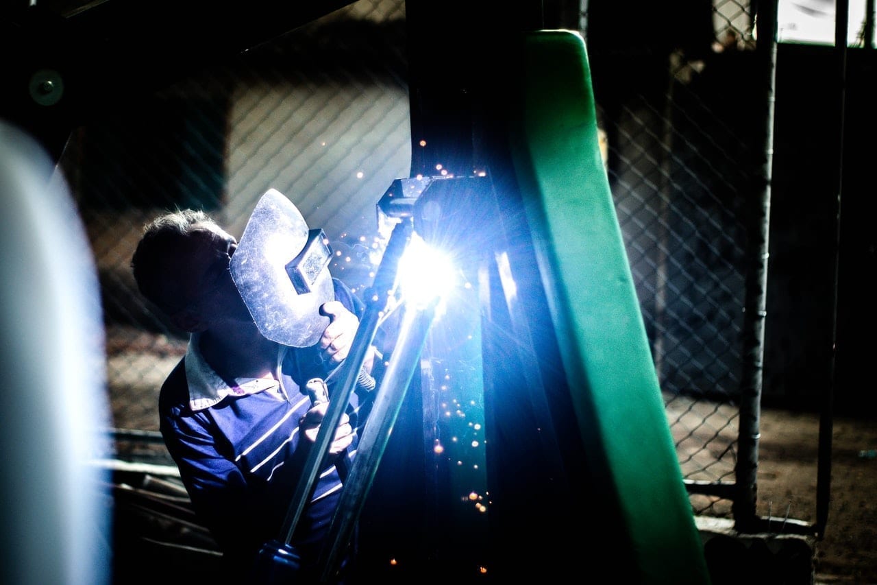 Um soldador trabalhando em um pedaço de metal.