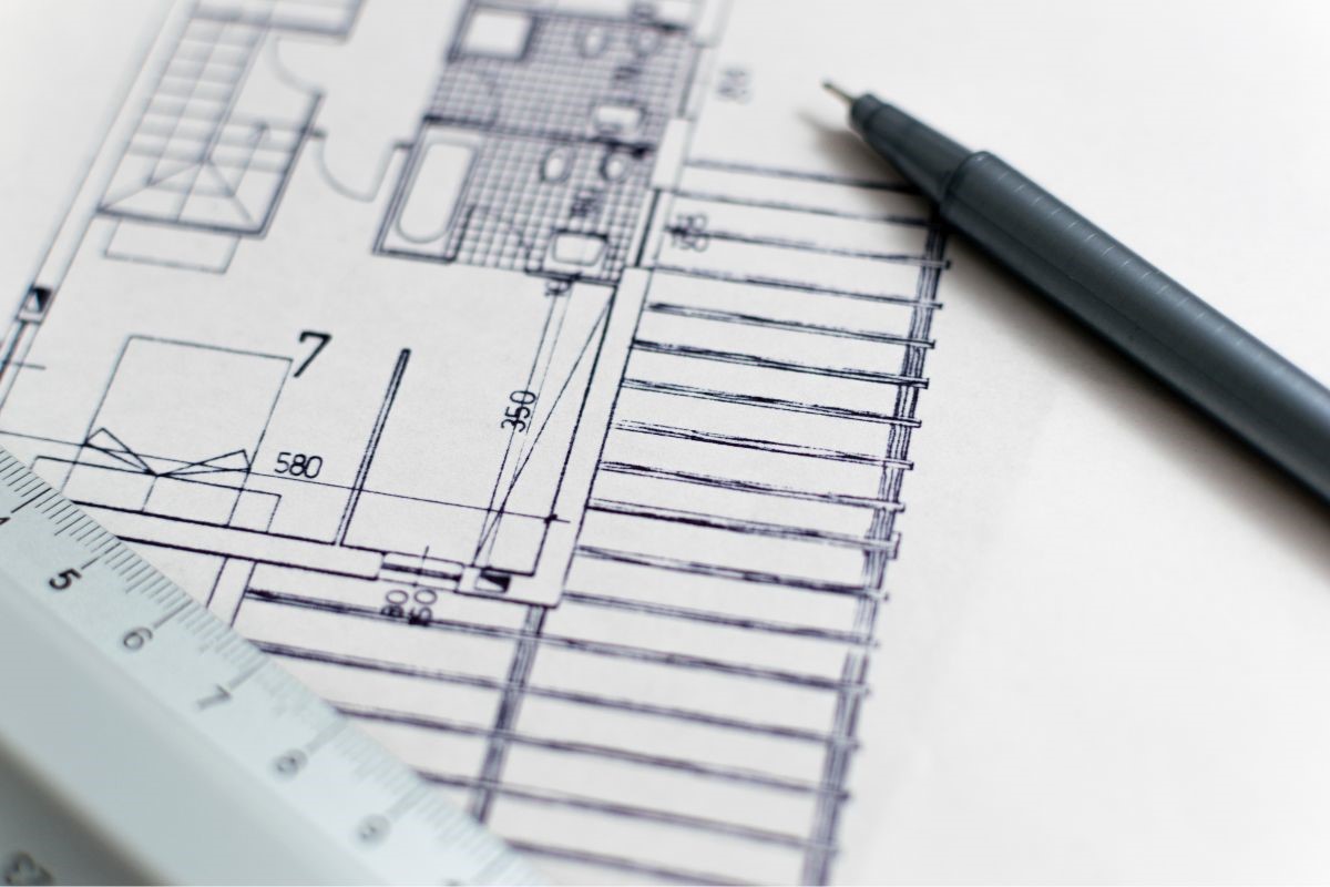 Um projeto de construção de uma casa desenhado com um lápis e uma régua.