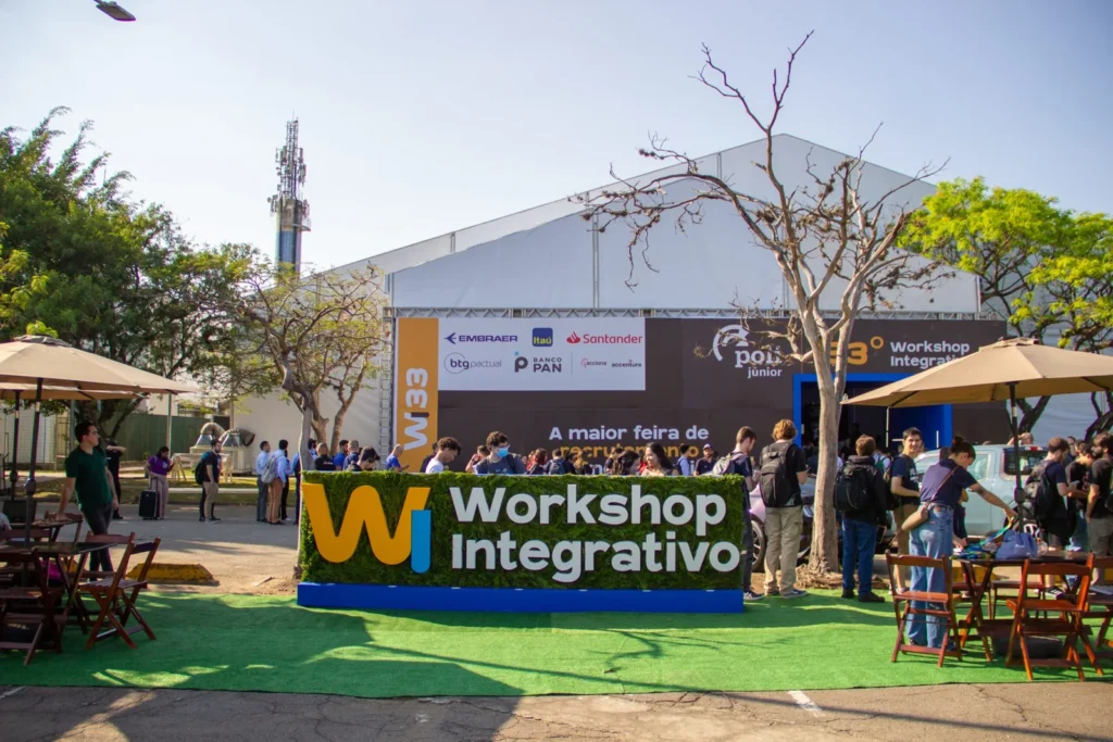 Uma multidão se reúne do lado de fora de uma grande tenda no "Workshop Integrativo".