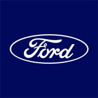 Logotipo da Ford com a palavra "Ford" em texto manuscrito, dentro de um oval branco, sobre um fundo azul escuro, lembrando um ambiente de oficina Integrativo.