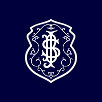 Um monograma "SI" branco, ornamentado e interligado dentro de um escudo decorativo em um fundo azul escuro simboliza o espírito do Integrativo.