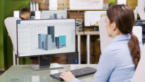 Uma mulher olhando para uma tela de computador explora as vantagens do BIM na construção.