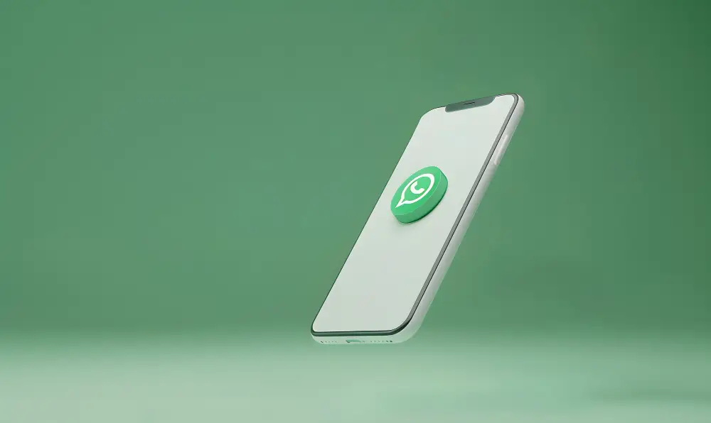 Smartphone moderno branco com o ícone flutuante do WhatsApp em 3D, sobre fundo verde-claro. Conceito de comunicação digital.