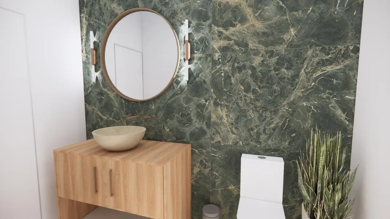 Refúgio Aurora | WhatsApp Image 2025 05 08 at 20.21.31 1 1 Banheiro moderno com parede de mármore verde, espelho redondo, bancada de madeira com pia, vaso sanitário branco, arandelas e uma planta alta no canto.